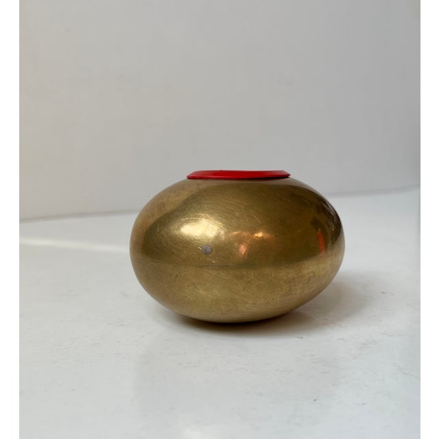 A very rare Egg shaped money bank (The Smile) in solid brass featuring a red removable money slot. Designed by the Danish...