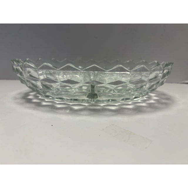 A matching pair of vintage clear pressed glass divided serving dishes, featuring an elegant oval form with sculpted...