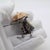 This vintage silver decorative object depicts an old goblin figure with an umbrella, crafted as a cabinet curiosity or...
