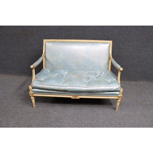 Louis XVI blue leatherette settee in cream & gold gilded frame with tufted cushion and nail head trim.