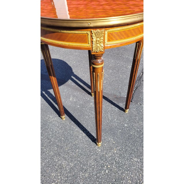 The surface of the top and around the apron is a complex pattern of parquetry inlays. There is a diversity of woods and...