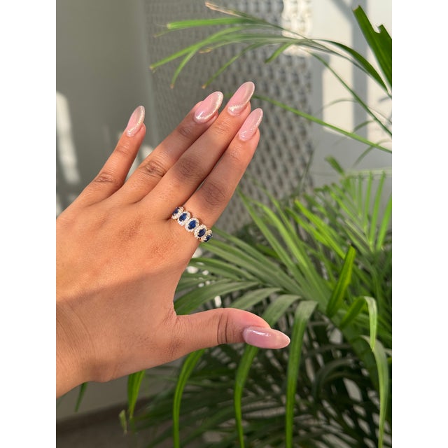 This half band ring features a 1.63 carat of oval blue sapphires set in 14K yellow gold. Each measuring approximately 5.17...