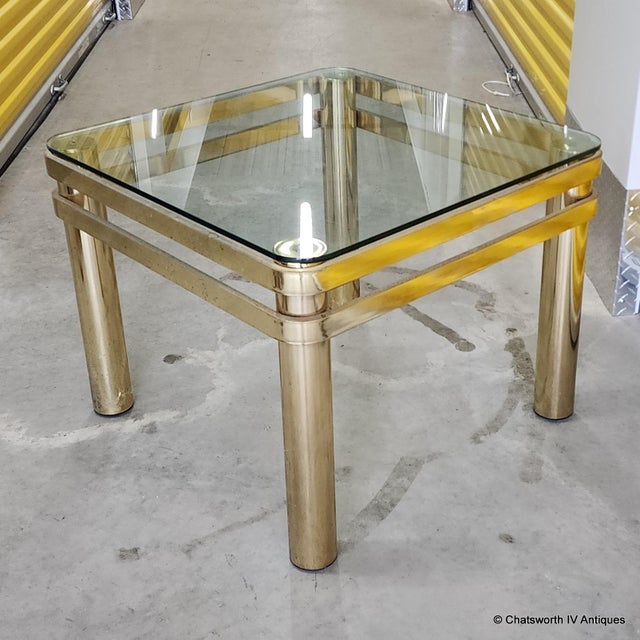Vintage modern glass top living room end table. Tubular legs with flat bar supports with a rounded corner glass top. No...