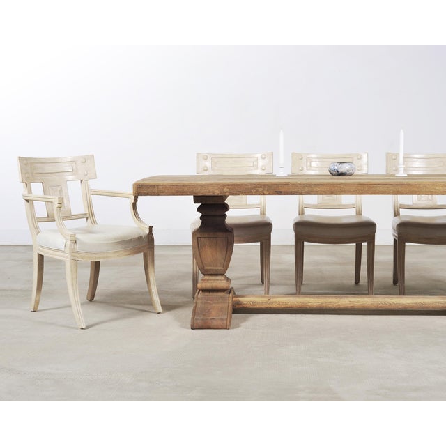 A substantial stripped oak trestle dining table crafted in the country Italian Provincial style. The large table features...