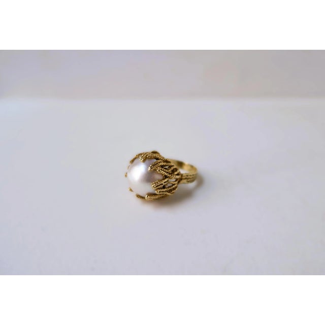 A beautiful white Mabe (or Mobe) pearl and gold cocktail ring with a twisted coral-like design, circa mid-20th century,...