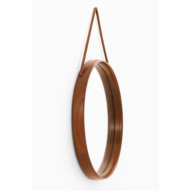 This large round mirror, designed by uno and östen kristiansson and produced by luxus in sweden during the 1950s,...