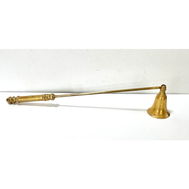 A refined vintage brass candle snuffer paired with a glass match striker featuring a strike plate base. The swiveling...