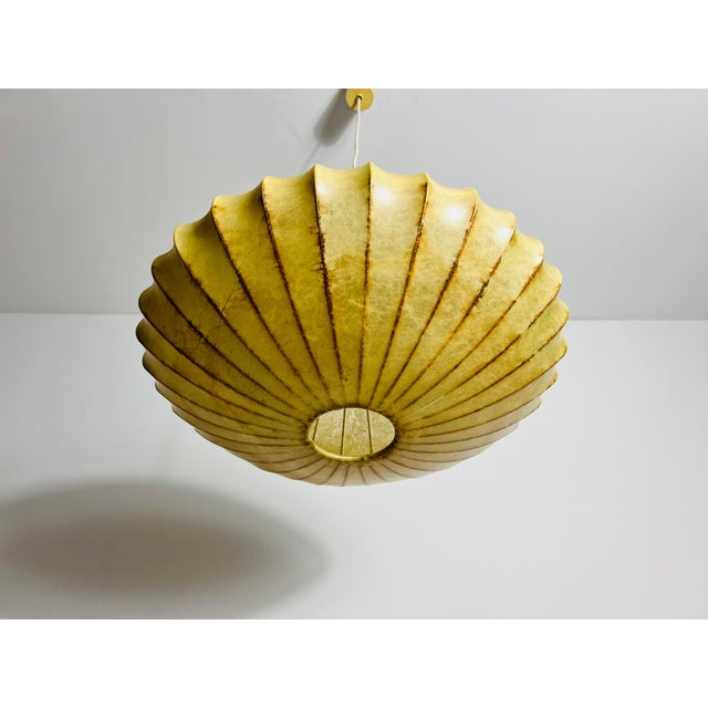 This saucer-shaped cocoon ceiling lamp from the 1960s exudes timeless elegance and vintage charm. Its cocoon material,...