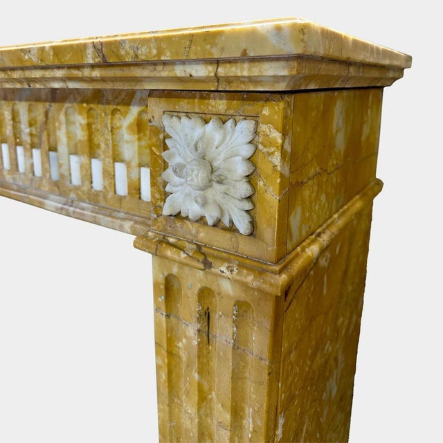 A period 18th century Louis XVI fireplace executed in Italian Siena marble, with Statuary marble accents. The tapering...
