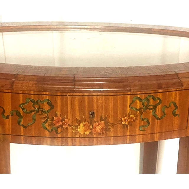 This beautiful oval hand-painted satinwood piece typically refers to a rare, antique furniture item, oval vitrine or...