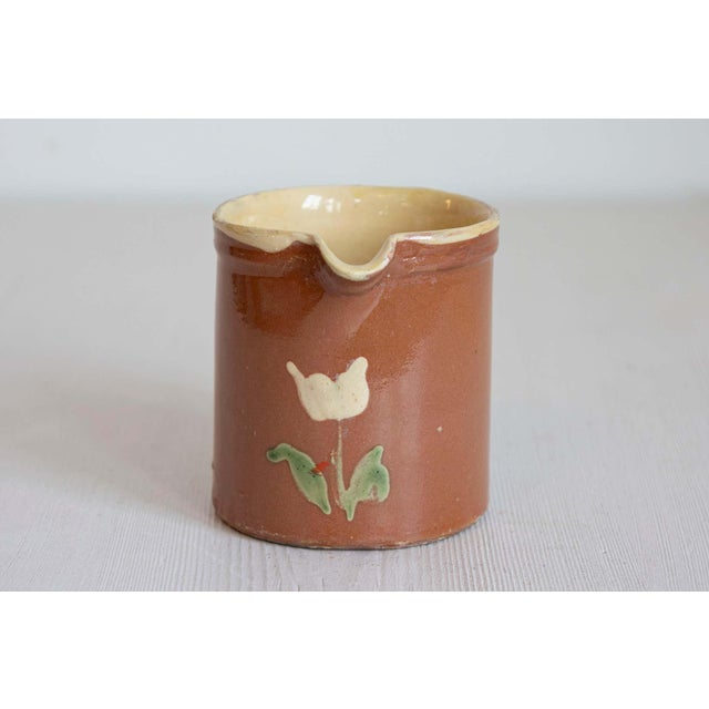 French redware pitchers from the 19th century, with white flowers, priced and sold individually. Created in France during...