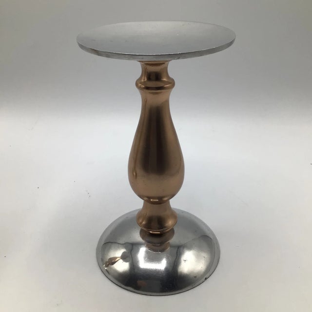 Pair of mid century modern rose aluminum and gold anodized aluminum pillar candle holders. These candle holders are...