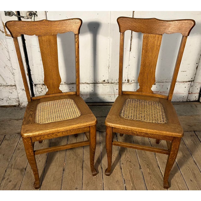Set of 2 oak vase back side chairs with woven caned seats. Circa 1920. Dimensions: W: 18.5" x D: 19" x H: 37.75" ; Seat W:...