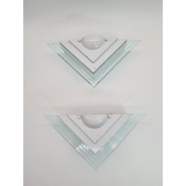 A pair of decorative wall sconces, model 1302s, by lighting house. A geometric, layered form with distinctive plastic...