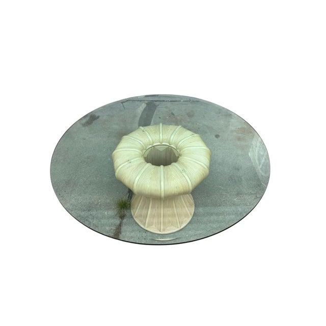 A striking sculptural dining table by Ficks Reed, featuring a dramatic hourglass-form pedestal base, 30” in diameter,...