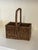 A beautifully handwoven rattan carrying caddy featuring a classic rectangular form with two divided compartments and a...