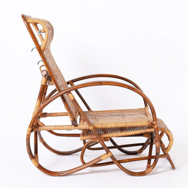 Vintage lounge chair crafted with bent bamboo and woven rattan in an elegant modern form featuring pullout footrest and...