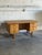 A substantial oak desk by Henning Kjærnulf pairs a broad rectangular top with two banks of three drawers. Sculpted drawer...