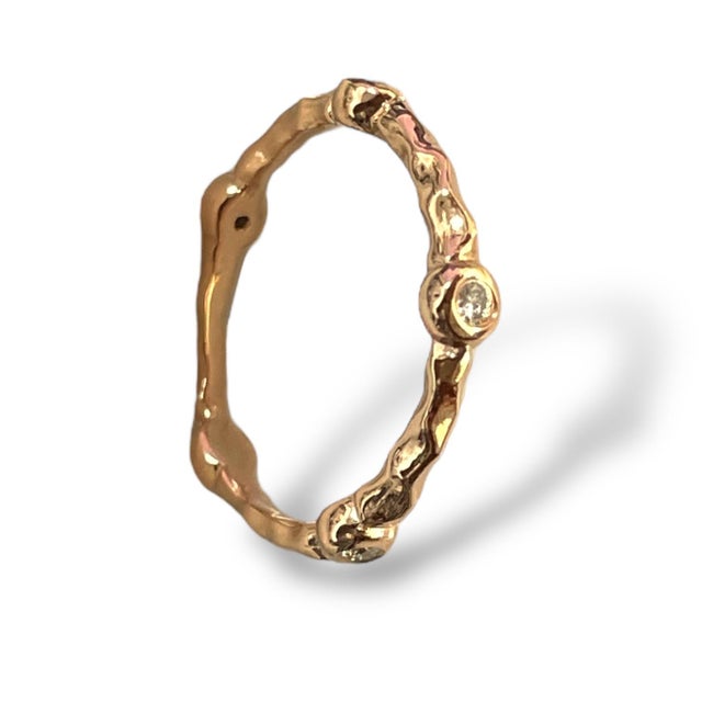 This exquisite 14K gold band features a nature-inspired textured design, beautifully complemented by sparkling diamonds....