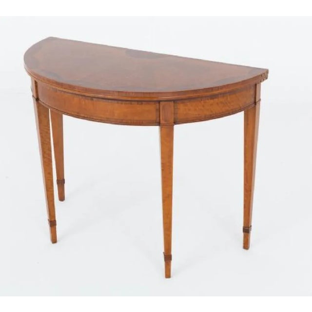 Hepplewhite style satinwood card table This card table is raised upon tapered legs with rosewood ankle straps Circa 1900...