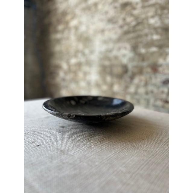 Add a dramatic, natural touch to your decor with this striking polished black fossil marble bowl. Crafted from solid...