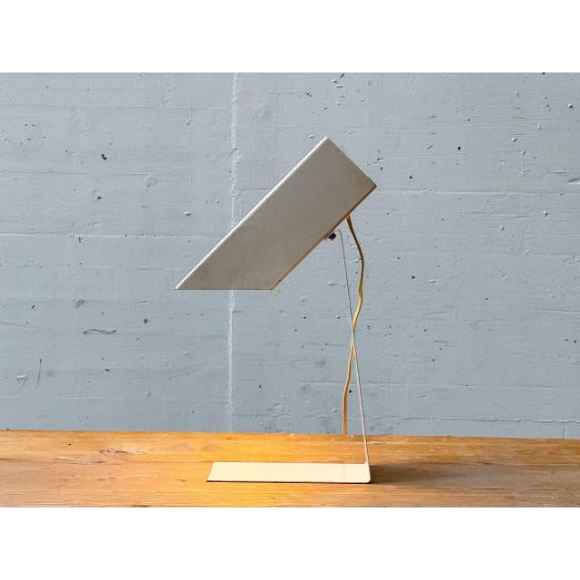 An architecturally minimalist table lamp from the 1980s with a clear, geometric design. Made of folded sheet metal, the...