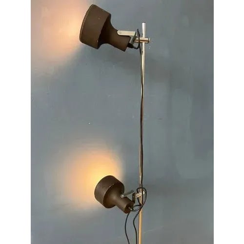 Mid century brown design floor lamp by the dutch brand Anvia. The two brown aluminium spots can be moved up and down the...
