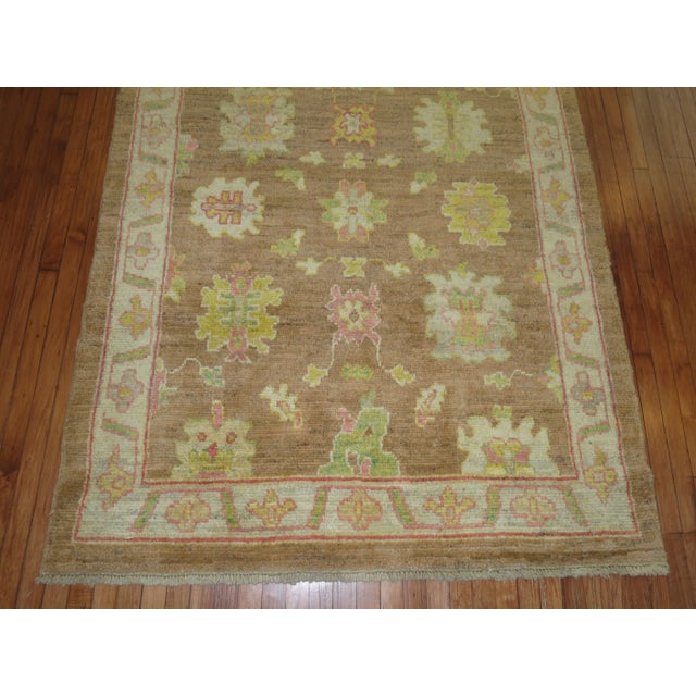 A one of a kind Turkish Oushak Rug with a feminine all over design on a coffee brown ground. Professionally Cleaned and...