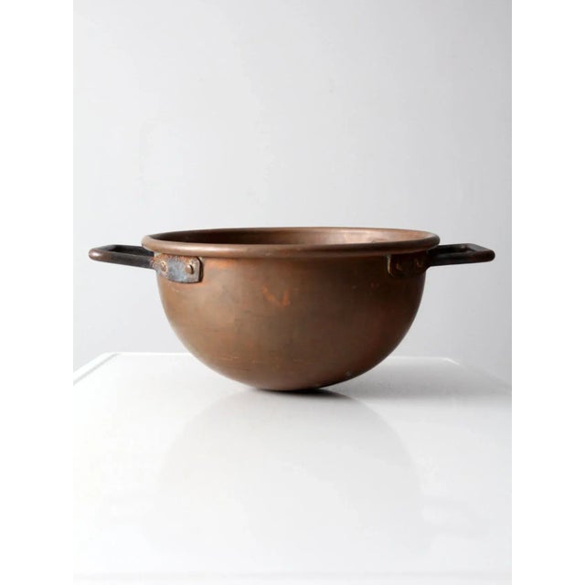 An antique copper chocolate pot featuring a substantial heavyweight form, rounded bottom, and sturdy iron handles....