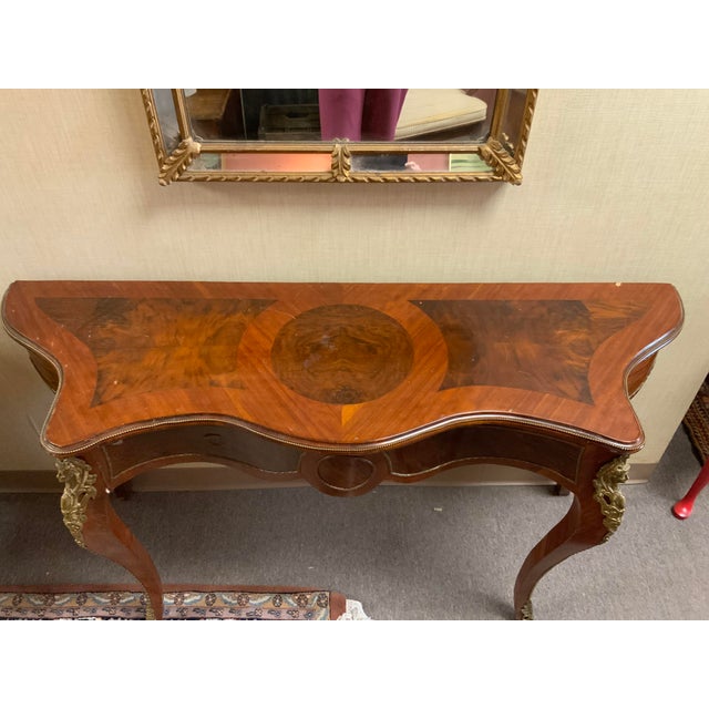 Mid 20th century reproduction of a French Louis Style console table. Brass beaded trim and ormolu decorate the top and...