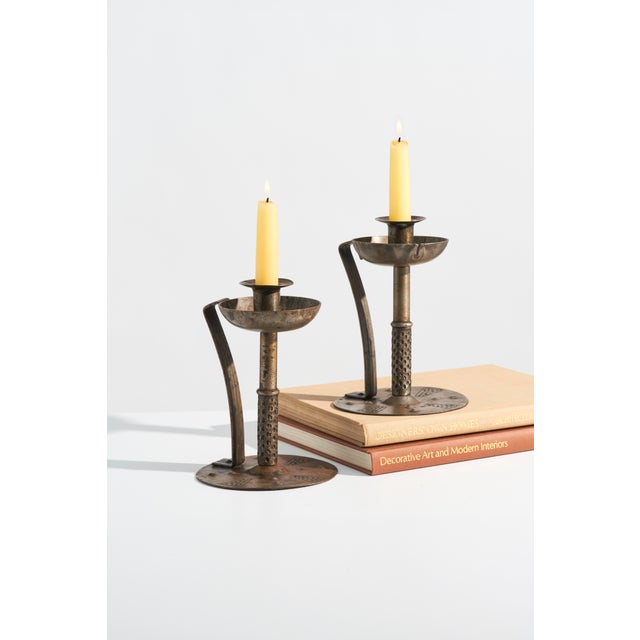 A pair of antique Goberg candle holders in hand-worked steel or iron, featuring a circular riveted base with geometric...