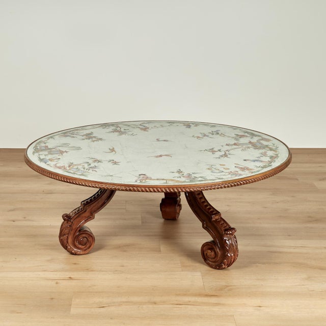 Chic Italian eglomise coffee table with a round top featuring Chinoiserie style reverse painting on a silver leaf...