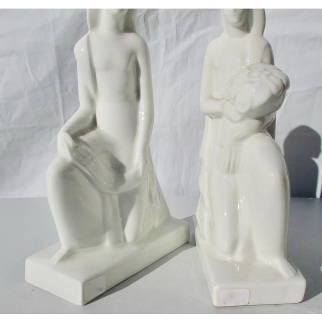 Pair of kneeling figures holding allegorical materials. Fine white blanc de chine porcelain by De Vegh working for...