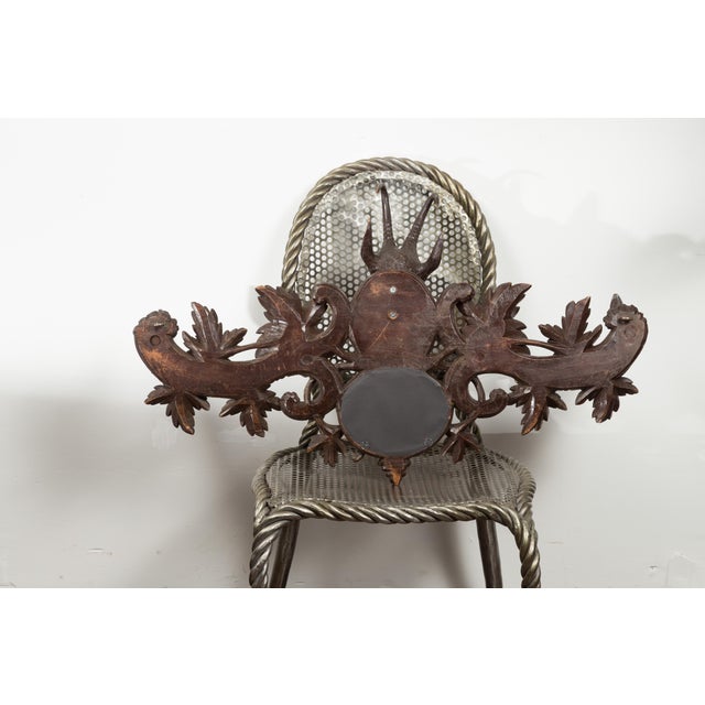A Black Forest period carved wooden plaque from the early 20th century, with chamois motif, foliage and petite mirror....