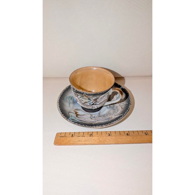 Cup and saucer marked "Made in Occupied Japan." (1945 to 1952) White, grey and gold dragon on cup with heavy impasto....