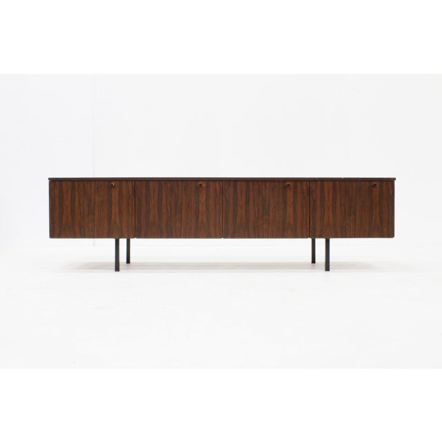 Vintage sideboard from the 1960s with beautiful wood grain. The sideboard offers ample storage space with four handy...