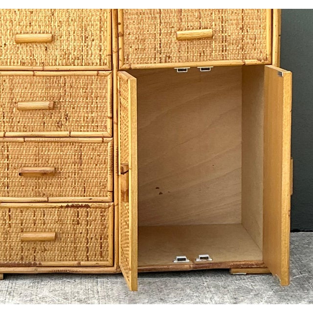 This vintage woven rattan and wood sideboard is a beautifully crafted example of mid-century design, blending natural...