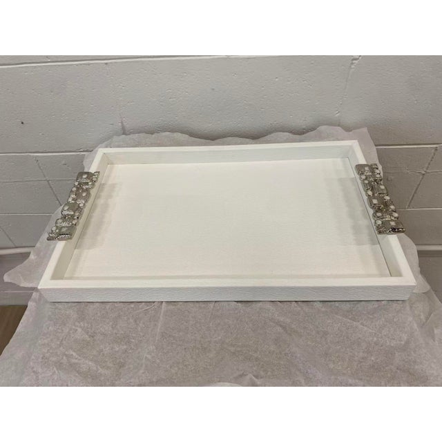 The Muse Tray is a stunning accent piece showcasing a textural look with pristine white tones. Two aluminum handles are...