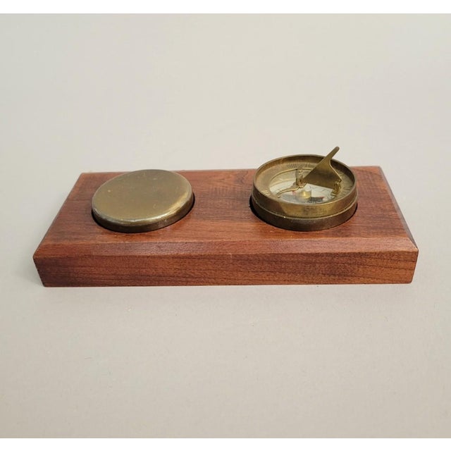 A mid-century brass sundial and compass by Son Manufacturing (Cherry Valley, New York), presented on its original fitted...
