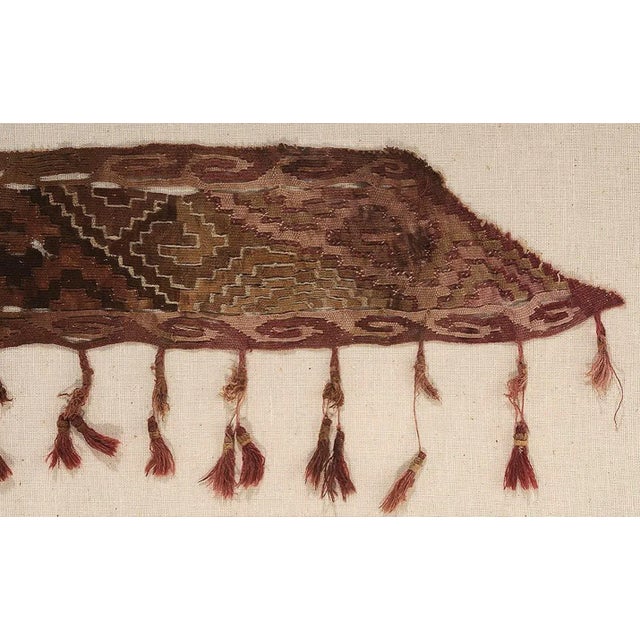 A fragment of antique Peruvian textile from Pre-Columbia era, nicely displayed in a matted metal frame. Likely from...