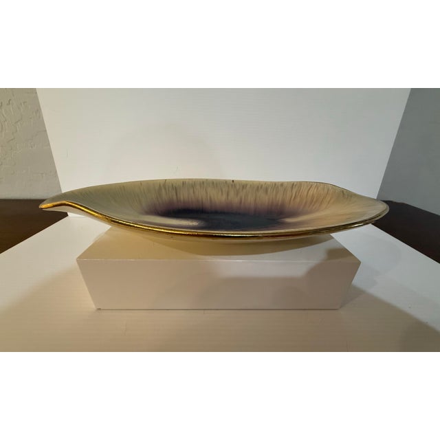 A sculptural mid-century West German pottery dish in an elegant elongated leaf form, finished in a deep brown-to-black...