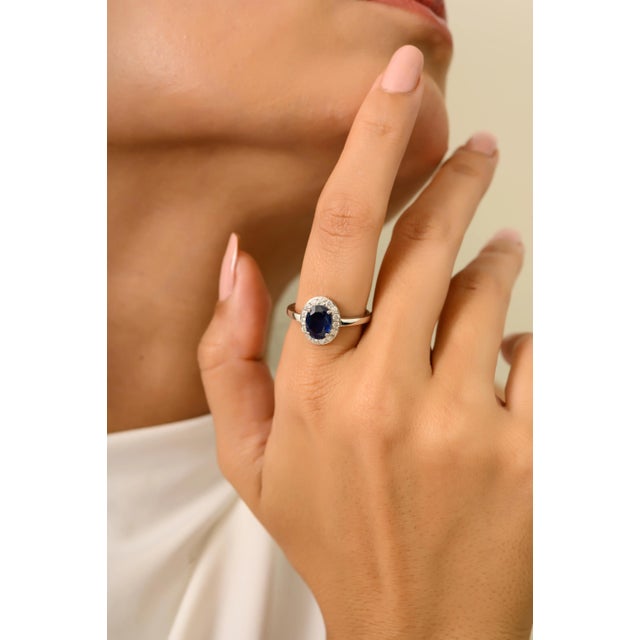 Elegant 1.23 Ct oval-cut blue sapphire ring accented with a sparkling diamond halo, beautifully crafted in 14K gold. A...