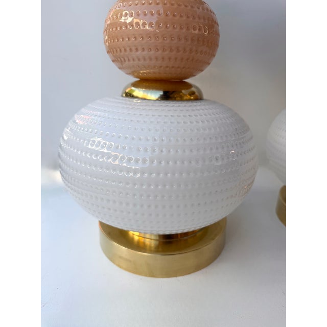 Pair of table or bedside lamps in brass, pink murano glass with white murano glass bulb textured globe shades....