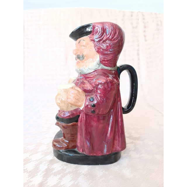 Vintage Royal Doulton Sir John Falstaff Toby jug depicting man in red and black hat, red jacket and black pants, brown...