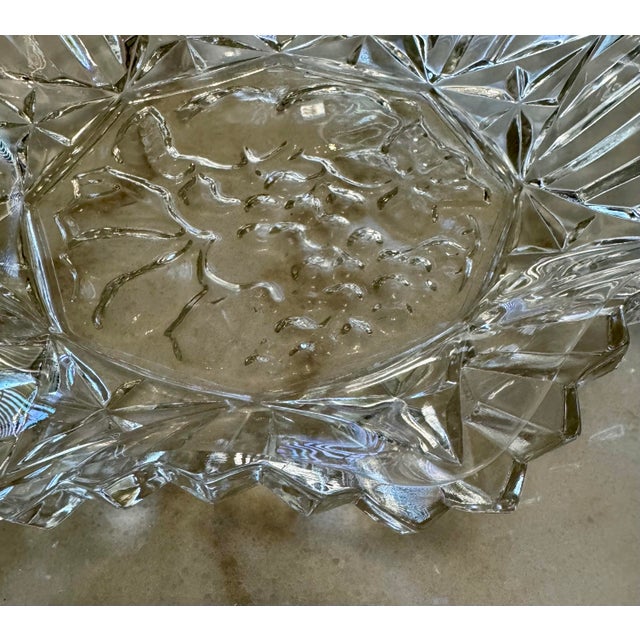 Beautiful vintage clear pressed glass serving bowl featuring a central embossed grape and leaf motif surrounded by...
