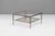 Brass framed French coffee table with magazine shelf below clear glass top. Circa 1950.