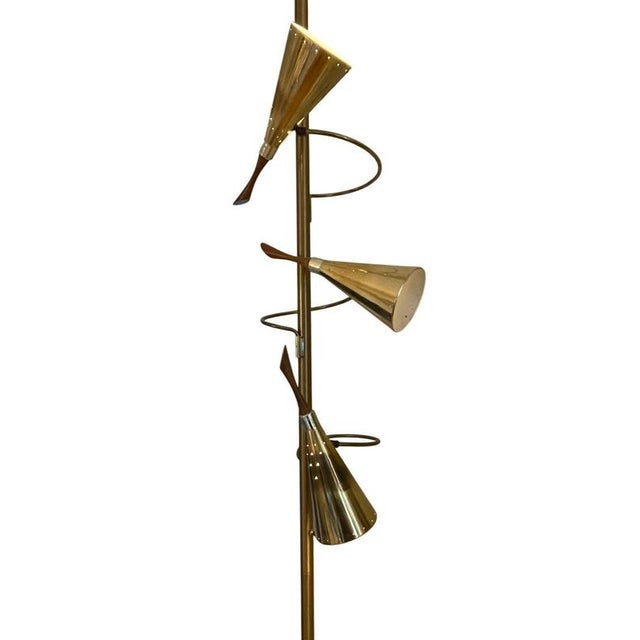A sophisticated mid-century tension pole lamp attributed to Stiffel, crafted in the 1950s. This elegant piece features a...