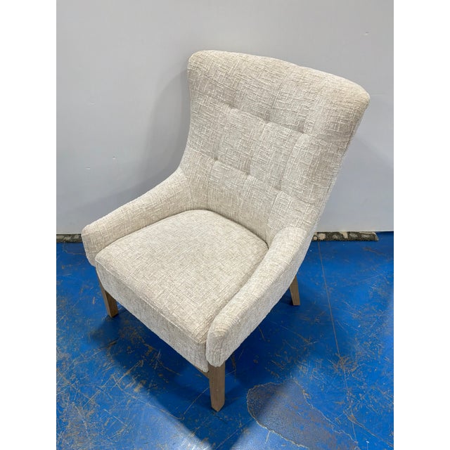 Stylish Modern Wing Chair. Nubby Cream Fabric, wood legs. Showroom floor sample.