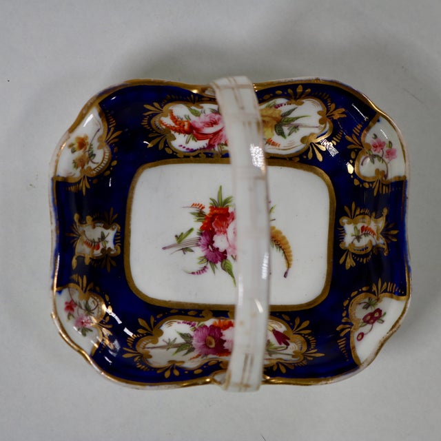 A small porcelain basket attributed to Coalport. Featuring typical Coalport decoration of naturally colored flowers in...