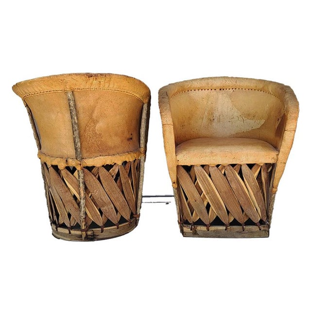 Enhance your space with this distinctive pair of vintage mid-century Mexican Equipale barrel chairs. Perfect for bringing...